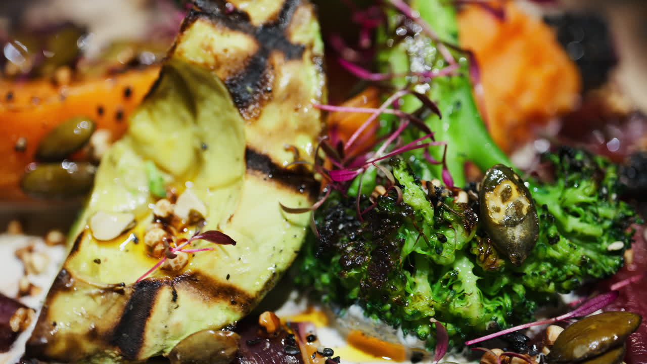 Close up of a salad with grilled avocado, sweet potato and broccoli on a plate at a restaurant