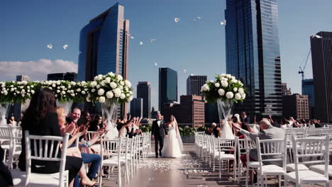 rooftop wedding ceremony with bride, groom, and guests amidst city skyline
