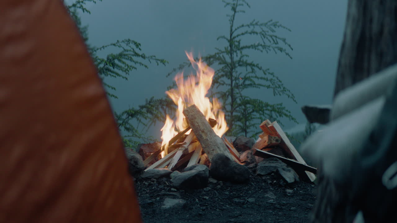 Campfire burning at a mountainside camp