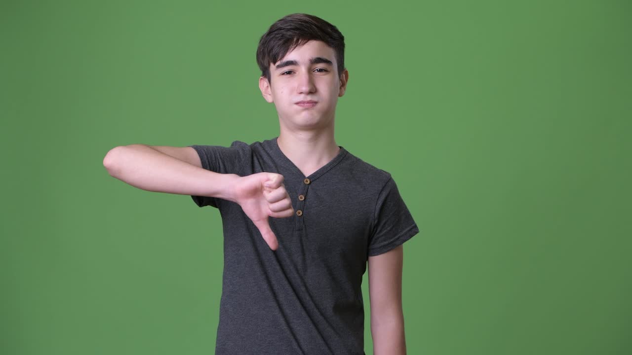 초록색 배경에 젊은 잘생긴 이란 십대 소년