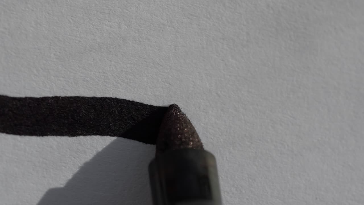 ⁇  종이 한 장 에 직선 을 그리는 검은색 샤르피 영구 마커 의 매크로 클로즈업  ⁇