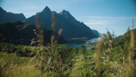 Wide-shot-of-verdant-green-landscape-at-the-coastline-with-mountains-and-blue-ocean