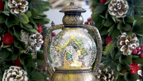 Snowglobe-with-child-in-the-manger-on-Christmas-background-decoration