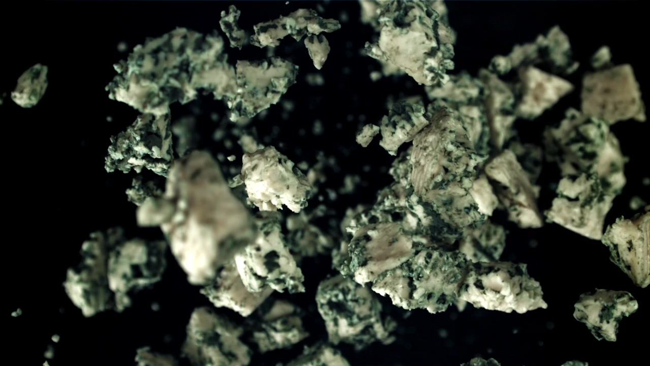 Blue Cheese Pieces Floating in Super Slow Motion on Black Background