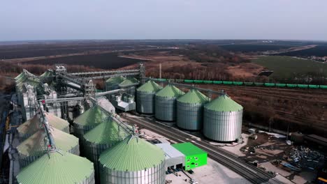 metal silos on field aerial view. large containers for storing and processing grains. silver grain elevators in farmland. storage tank view from above. silo with grain.