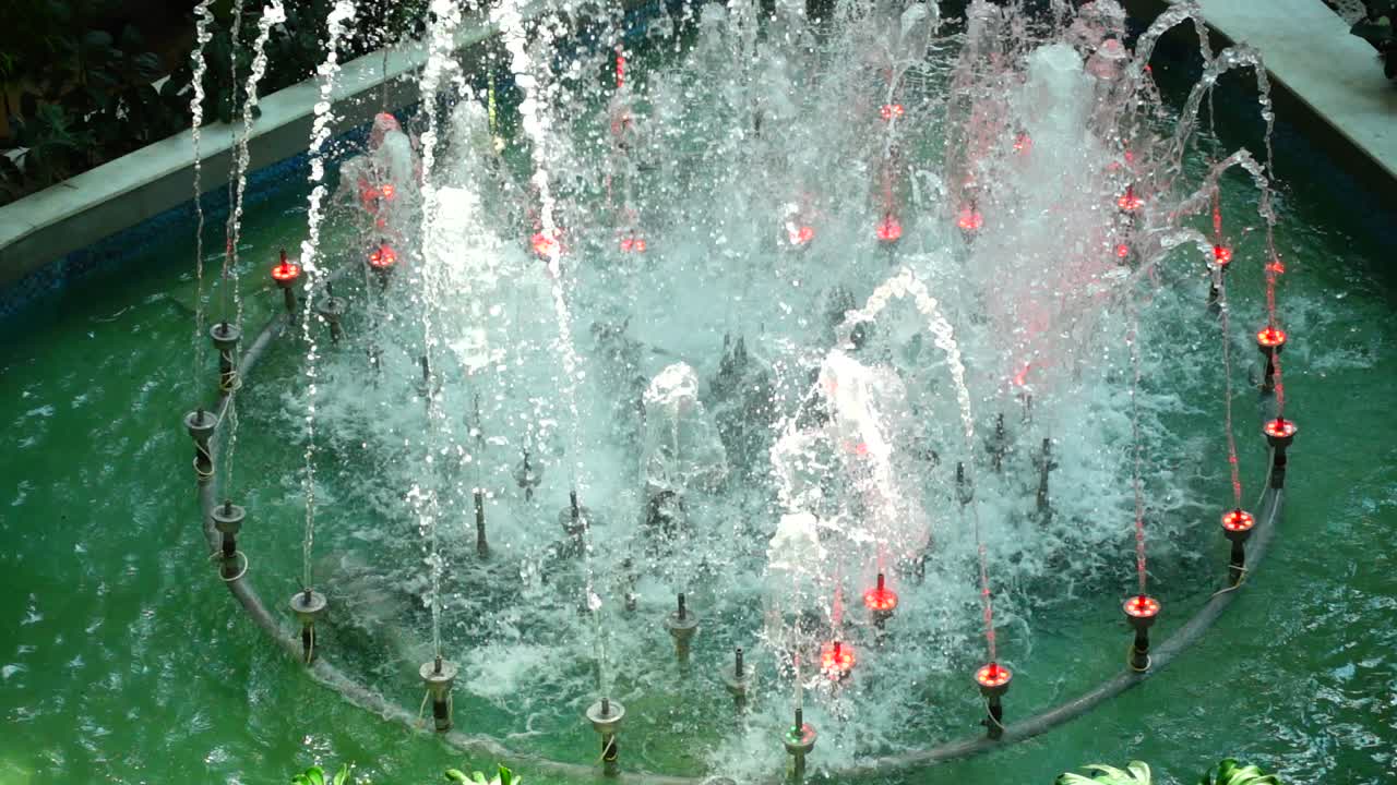 Getti d'acqua della fontana nel centro commerciale. Movimento rallentato