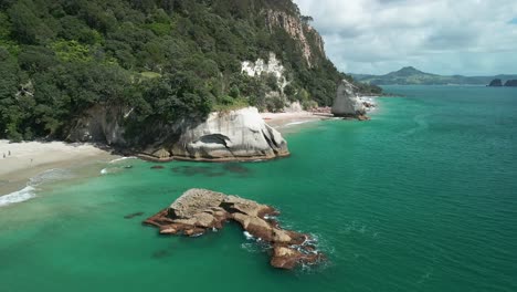 Einsamer-Strand-Gegen-Bergklippe