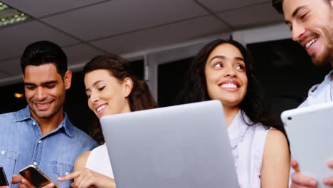 ejecutivos felices usando tabletas digitales, portátiles y teléfonos móviles
