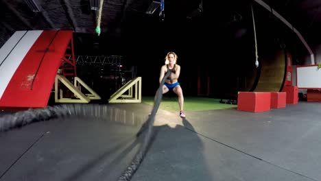 mujer atlética realizando ejercicios de cuerda de batalla 4k