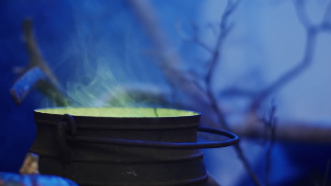 Video eines Topfes mit grüner Flüssigkeit und Rauch auf blauem Hintergrund