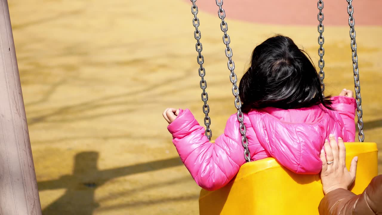 Bambino che si diverte su un'altalena nel parco giochi nel parco pubblico