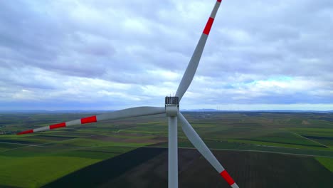 primer plano de las hélices de un aerogenerador girando, produciendo energía verde en el campo