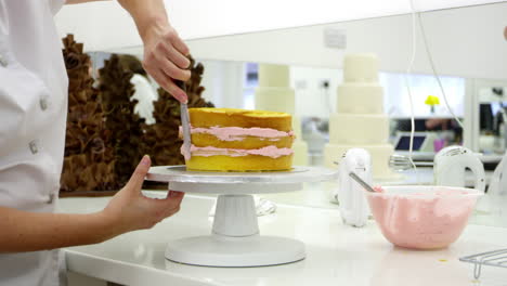 Nahaufnahme-Einer-Frau-In-Einer-Bäckerei,-Die-Kuchen-Mit-Zuckerguss-Dekoriert