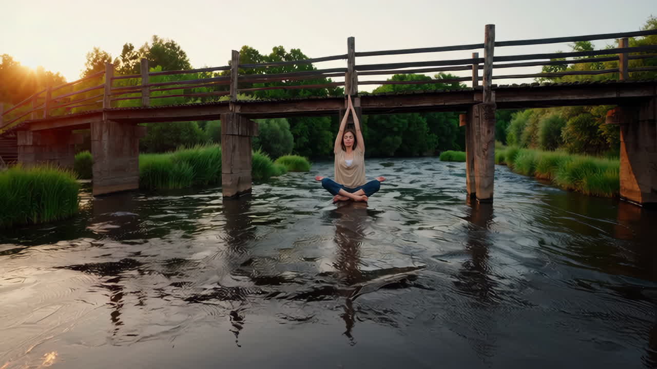 Woman meditating in a river under a bridge