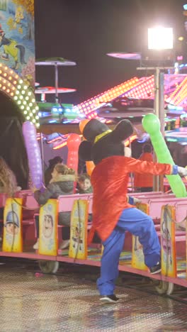 mascot dancing on a carnival ride at night