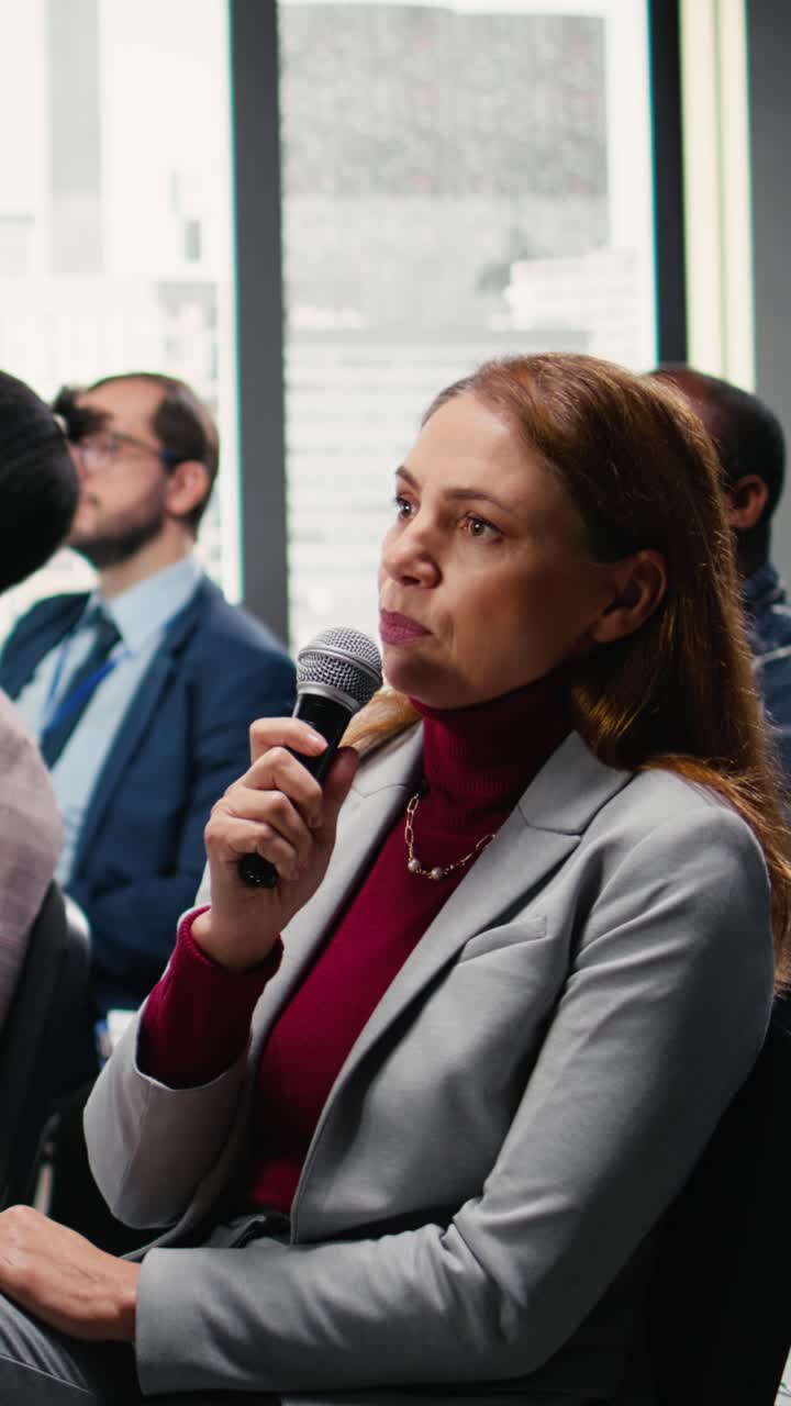 Video verticale di una donna d'affari che alza la mano, pone domande e partecipa a un dibattito