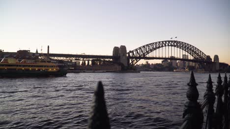 ferryboat sailing towards sydney harbour bridge at sunset in sydney, nsw, australia