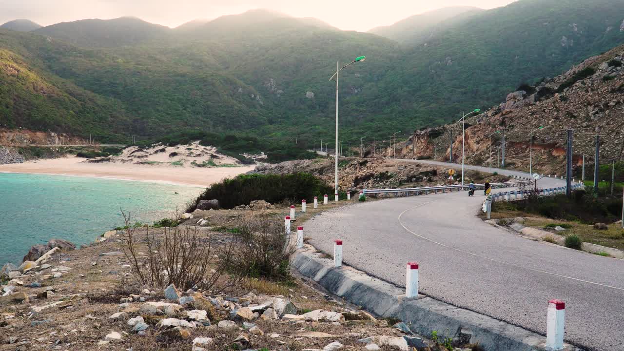 Epic surf trip on motorbikes by sea with mountain scenery in golden sunlight