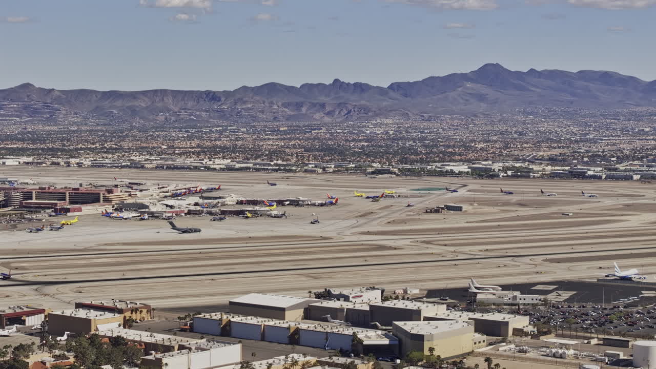 Las Vegas Nevada Aerial v96 zoomed low flyover Strip blvd, panning views capturing airport set against suburbs and a majestic mountain backdrop in daytime - Shot with Mavic 3 Pro Cine - Apr 30th 2024