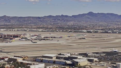 las vegas nevada aerial v96 zoomed low flyover strip blvd, panning views capturing airport set against suburbs and a majestic mountain backdrop in daytime - shot with mavic 3 pro cine - apr 30th 2024