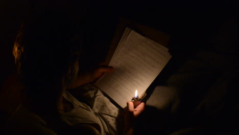 a soldier lighting a zippo lighter to read a letter the dark