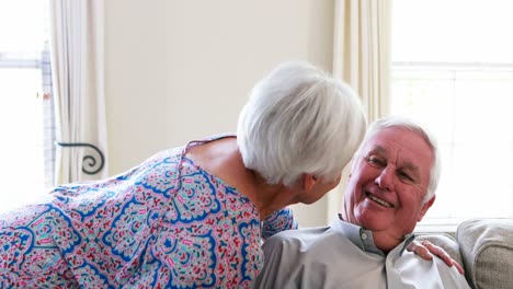 Ältere-Frau-Küsst-älteren-Mann-Im-Wohnzimmer