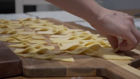 Person-Laid-Twisted-Dough-Of-Angel-Wings-On-The-Wooden-Chopping-Board