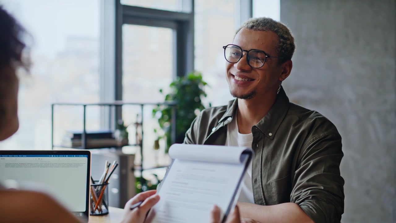 Cheerful man discussing documents recruiter woman. Job interview office meeting.