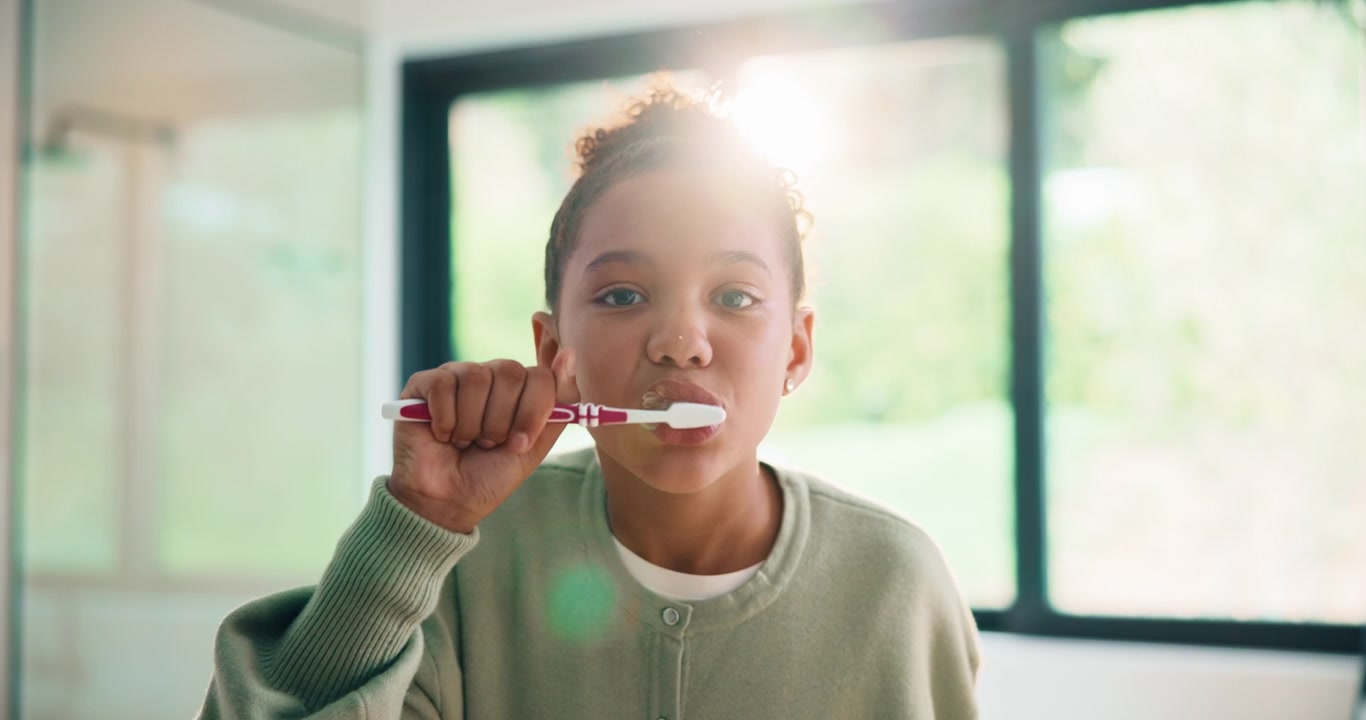 Ragazza Giovane che si Lava i Denti in un Bagno Luminoso
