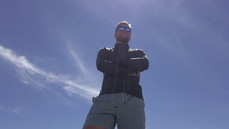 Man-standing-proudly-looking-up-low-angle-sky-tilt-Rockies-Kananaskis-Alberta-Canada