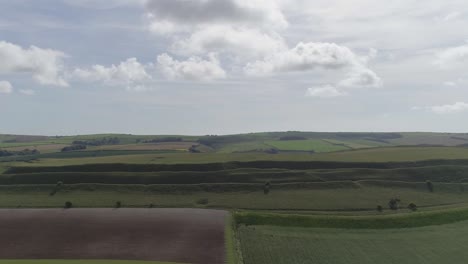 Aerial-tracking-back-centring-on-the-grand-iron-age-hill-fort,-Maiden-Castle