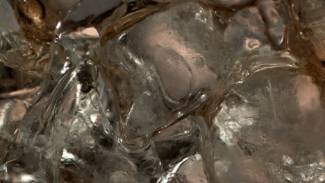 yummy liquid runs into the cocktail glass over the ice in 1000+ fps slow-motion