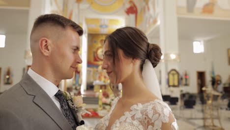 Hermosa-Pareja-De-Recién-Casados-Abrazando-Al-Novio-En-Una-Antigua-Iglesia,-Ceremonia-De-Boda,-Matrimonio