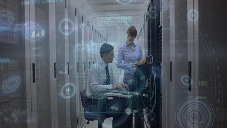 Animation-of-data-processing-over-two-caucasian-server-room-workers