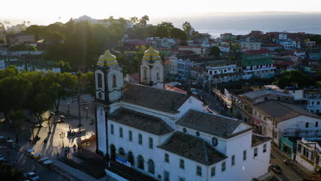 Aerial-view-of-Nosso-Senhor-do-Bonfim-church-back-side,-the-neighbourhood-and-the-ocean-at-background,-Salvador,-Bahia,-Brazil