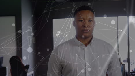 animation of network of connections against portrait of african american man smiling at office
