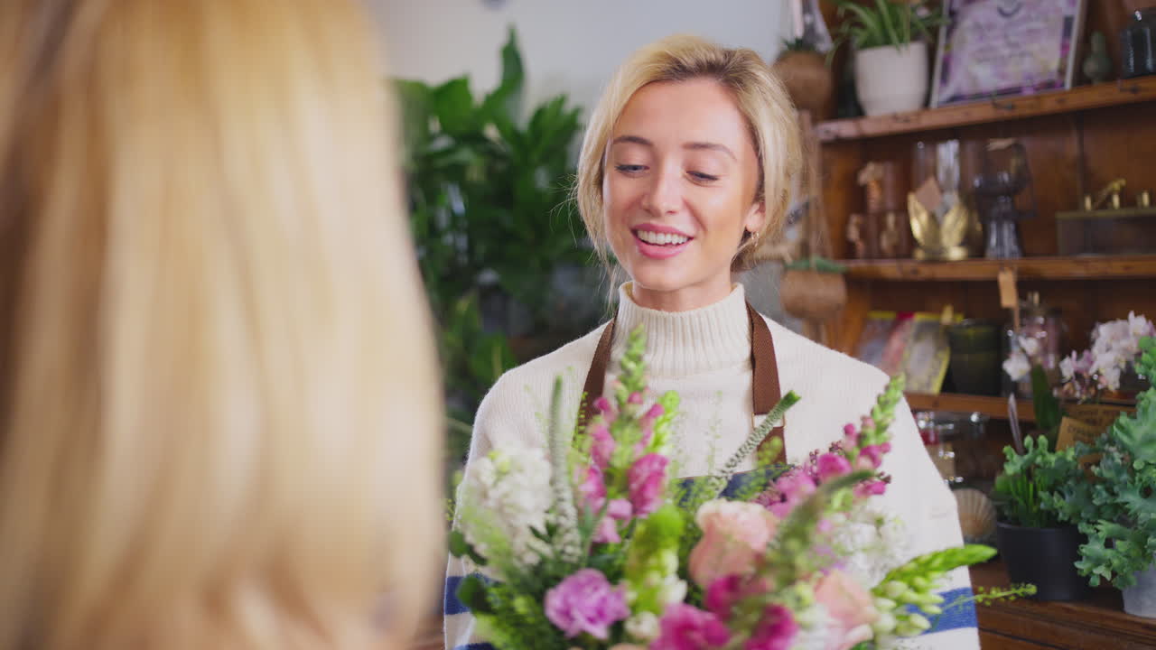 Cliente donna in un negozio di fiori che acquista un bouquet di fiori