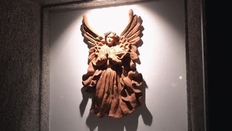 terracotta angel sculpture in artistic lighting