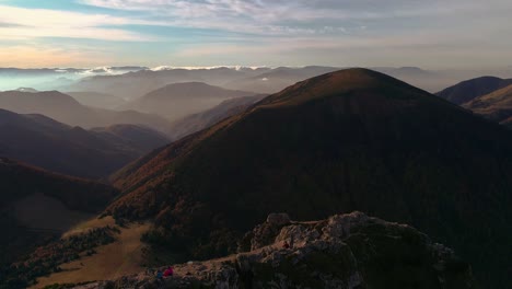 Drohne-Fliegt-Rückwärts-Und-Enthüllt-Eine-Unglaubliche-Bergkette-Bei-Sonnenuntergang-Mit-Wolken