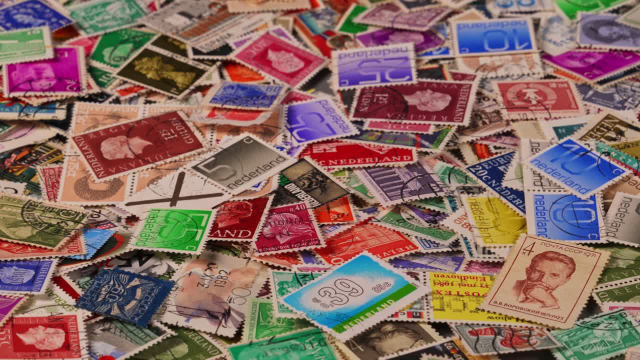 Colecionando selos coloridos de vários países em uma mesa grande