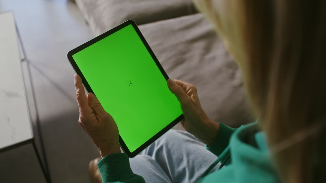 mujer usando una tableta con pantalla verde