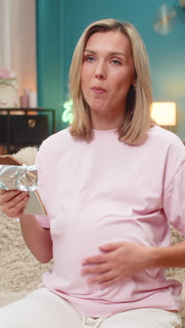 Pregnant woman tasting dark chocolate rolling eyes in delight rubbing belly enjoying sweet pleasure