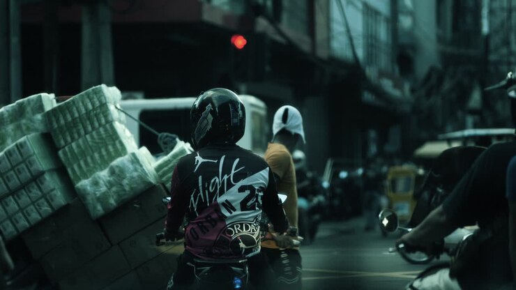 Busy City Street Scene with Motorcyclist Carrying a Heavy Load