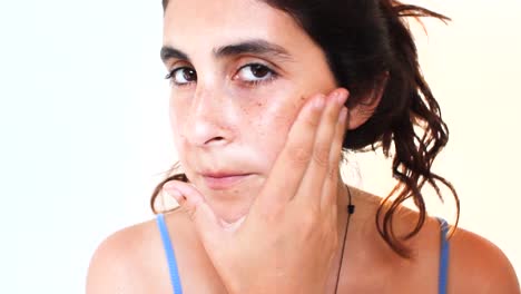 closeup of natural girl with no makeup applying face cream - skin care concept