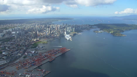 downtown vancouver and bc place helicopter shot looking west towards coal harbour and stanley park in british columbia