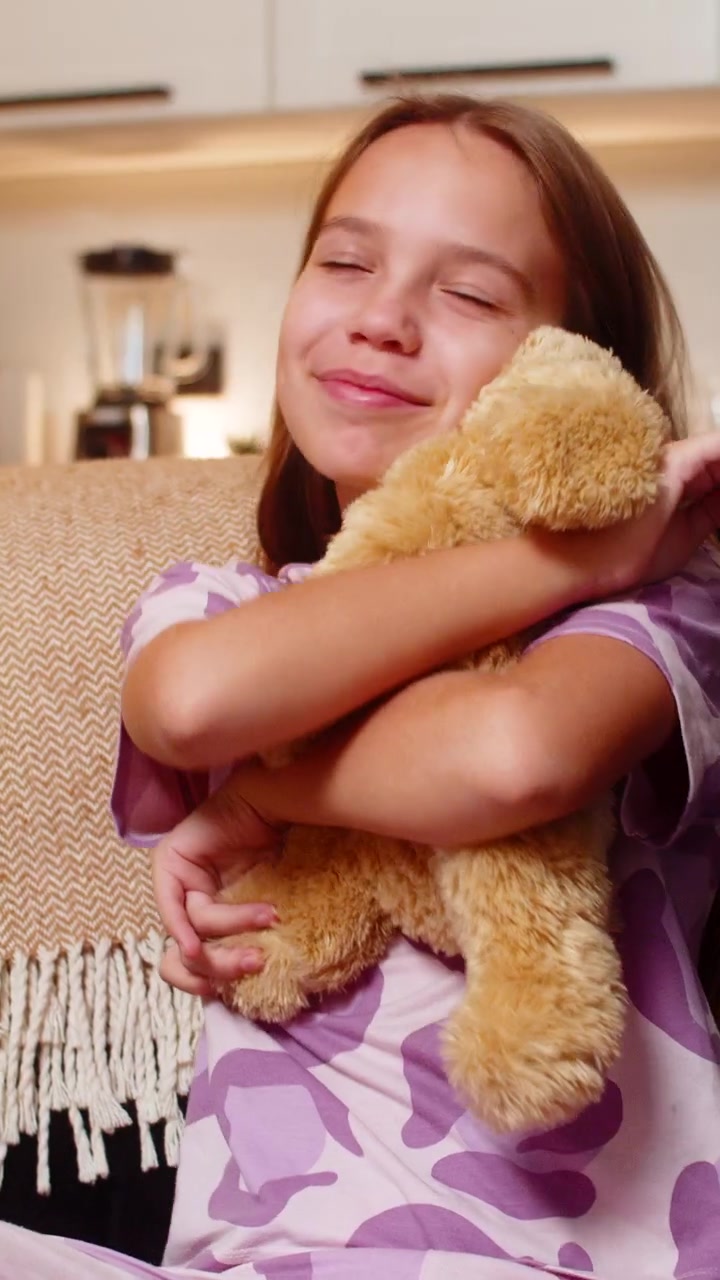 Una ragazza adolescente abbraccia un morbido peluche a forma di cane, sorride. L'abbraccio caloroso e il tocco delicato mostrano un animo gentile, un tenero momento di gioia.
