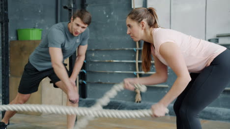couple working out with ropes in gym