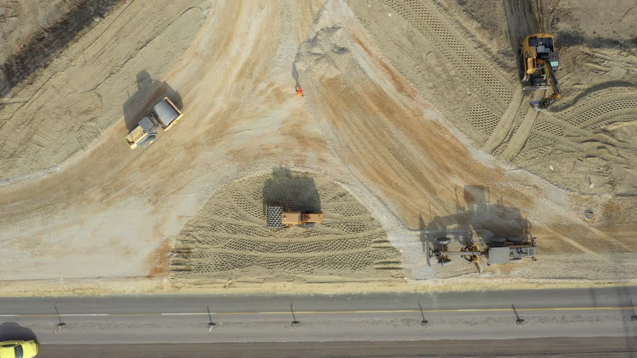 vista aérea en el nivelador como fracción de nivelamiento sobre el sitio de construcción y el rodillo de la carretera es la base de compactación para la nueva rotonda de tráfico
