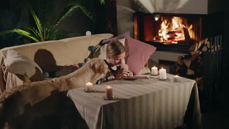 woman and dog by the fireplace, writing a letter