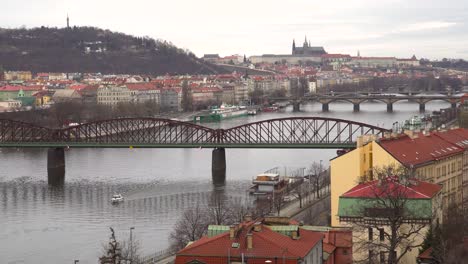 view over prague river, with castle in the distance on grey and cloudy winter day